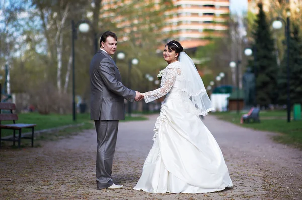 Glückliche Braut und Bräutigam bei einem Hochzeitsspaziergang — Stockfoto