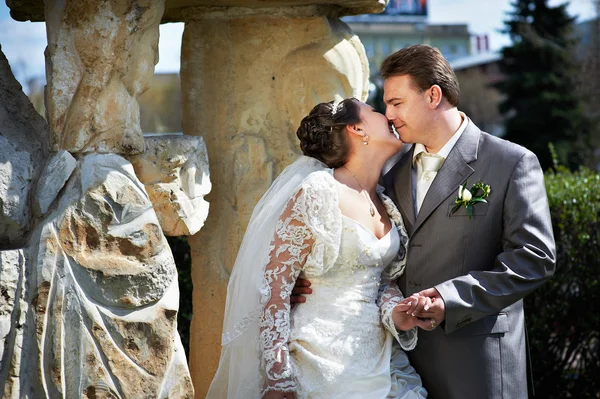 Happy bride and groom about ancient column — Stock Photo, Image