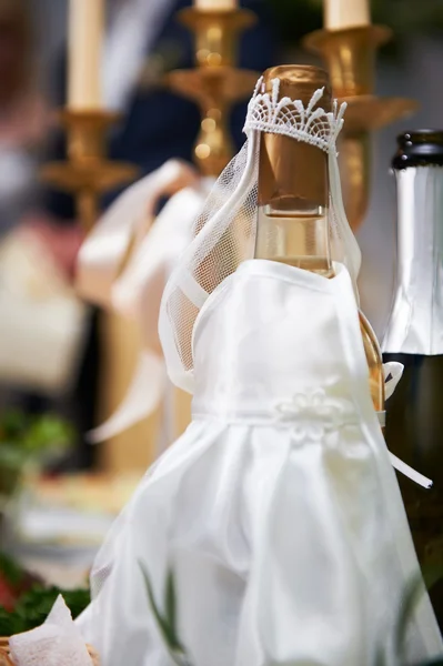 Botella de champán en trajes de novia — Foto de Stock