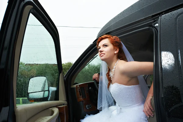 Beauty bride into big car — Stock Photo, Image