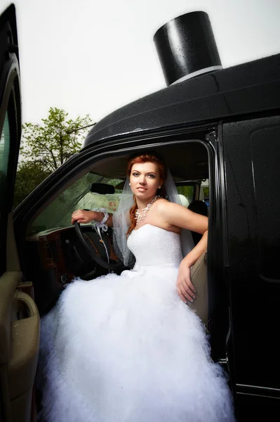 Bellezza sposa in grande auto nera — Foto Stock