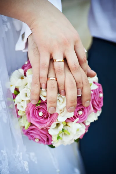 Mãos com anéis de ouro do casamento — Fotografia de Stock