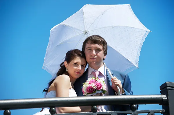 Szczęśliwa panna młoda i pan młody z parasolem — Zdjęcie stockowe