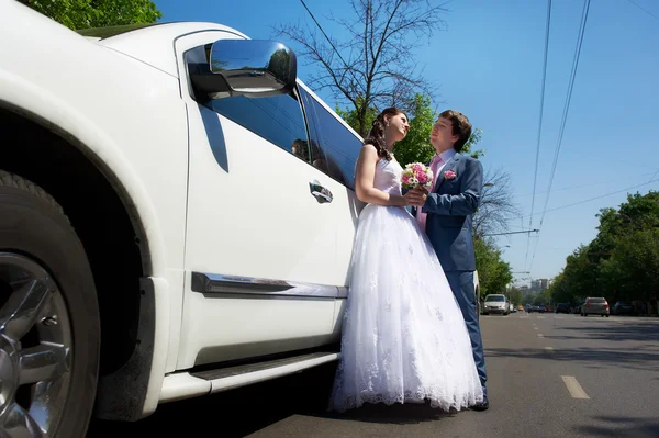 Noiva e noivo sobre a limusina do casamento — Fotografia de Stock