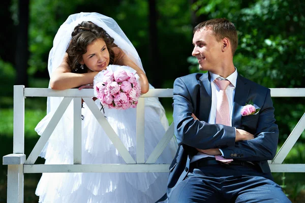 Mariée et marié sur le banc dans le parc — Photo