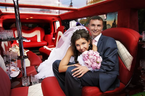 Bride and groom in wedding limousine — Stock Photo, Image