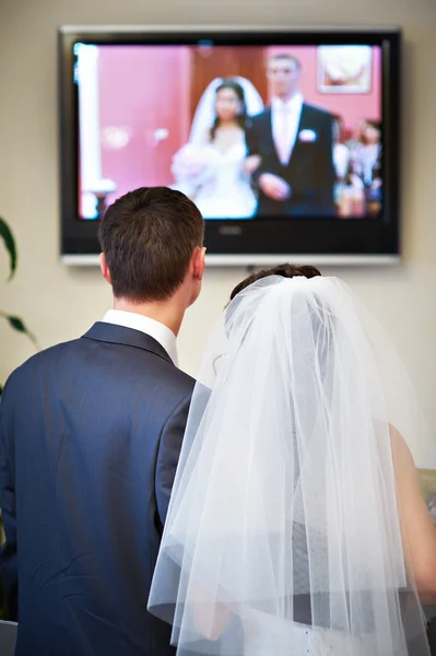 Bruden och brudgummen titta på video av hans bröllop — Stockfoto