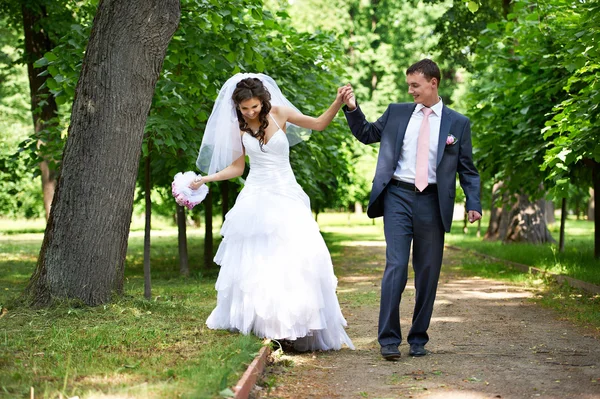 Gelukkige bruid en bruidegom in schaduwrijke steegje — Stockfoto