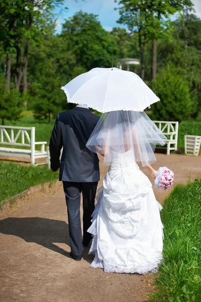 Šťastné nevěsty a ženicha jde podél cesty — Stock fotografie