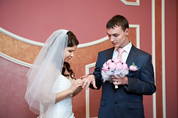 美しさの花嫁のエレガントな新郎の指に結婚指輪を着ています。 ストック写真