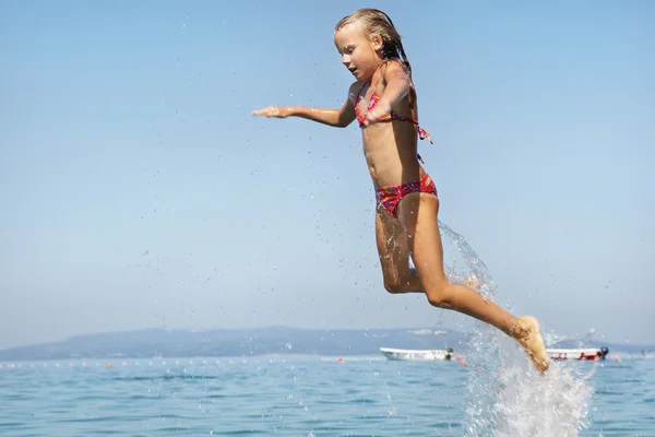 Little girls jumping out of the water — Stock Photo, Image
