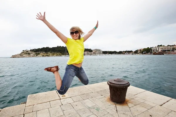 Młoda kobieta wesoły skoki na molo — Zdjęcie stockowe