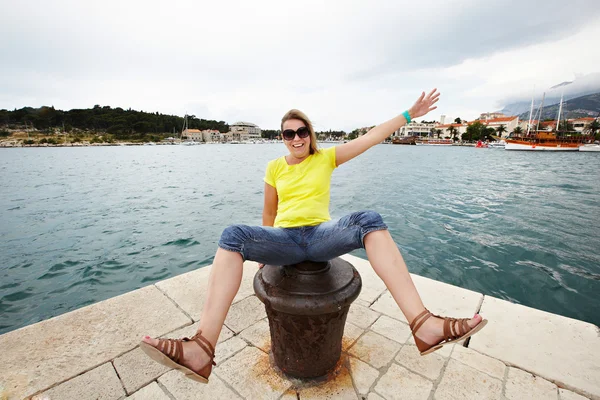 Joven mujer alegre sentada en el muelle — Foto de Stock