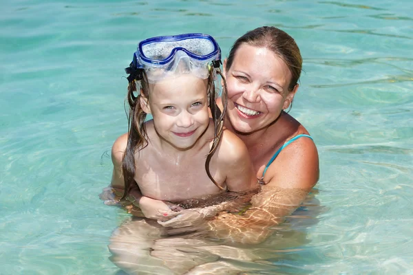 Glückliche Mutter und Tochter schwimmen im blauen Wasser — Stockfoto