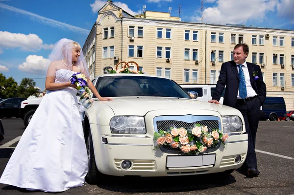 Brautpaar über Hochzeitslimousine — Stockfoto