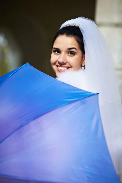 Schöne Braut mit blauem Regenschirm — Stockfoto