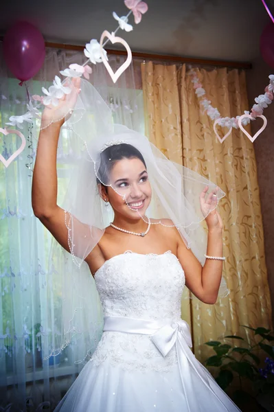 Счастливая невеста играет свою вуаль — стоковое фото