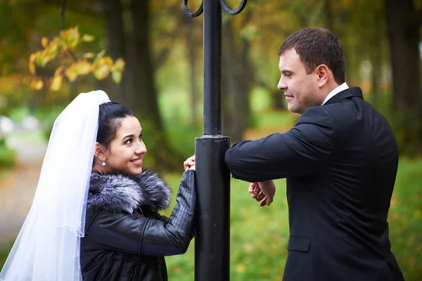 Happy bride and groom in autumn park — Stock Photo, Image