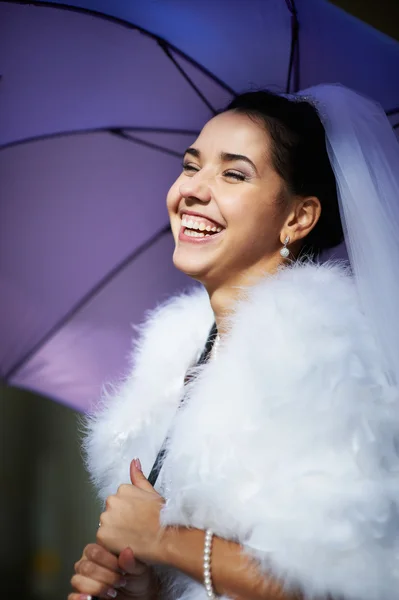 Freudige Braut mit blauem Regenschirm — Stockfoto