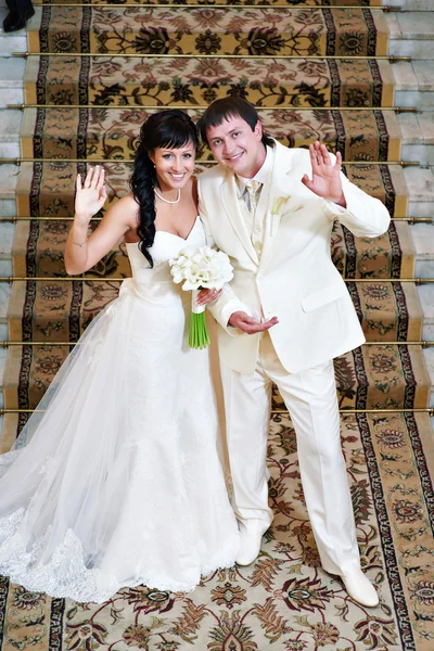 Glückliche Braut und Bräutigam vor einem Teppich — Stockfoto