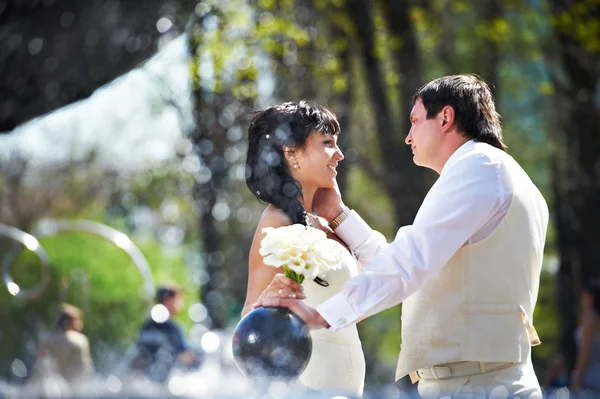 Happy bride and groom with bouquet — Stock Photo, Image