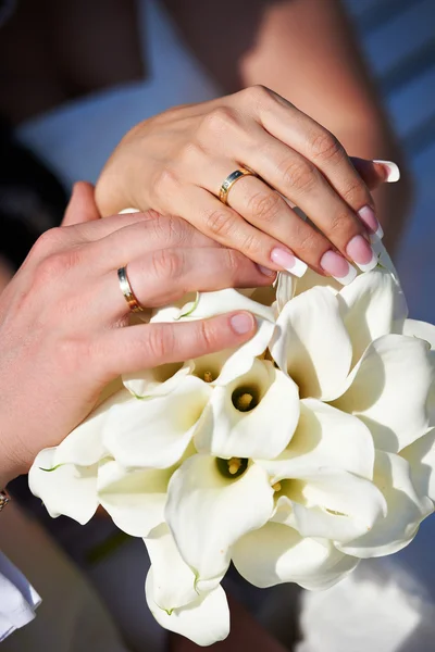 Ruce s svatební zlaté prsteny šťastní novomanželé — Stock fotografie