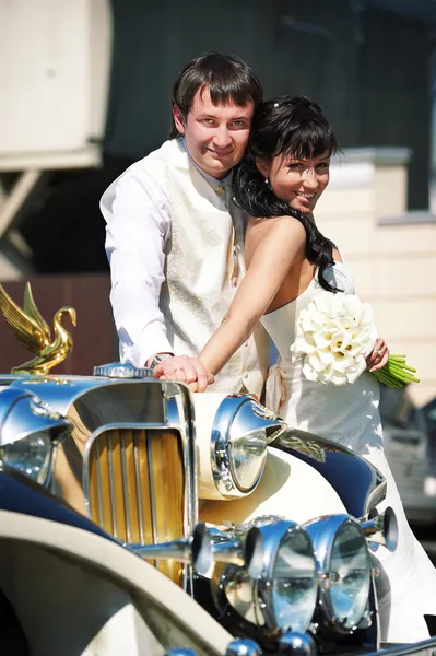 Felice sposo e sposa su limousine retrò — Foto Stock