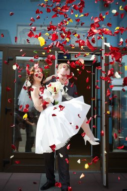 Happy newlyweds bride and groom with petals clipart