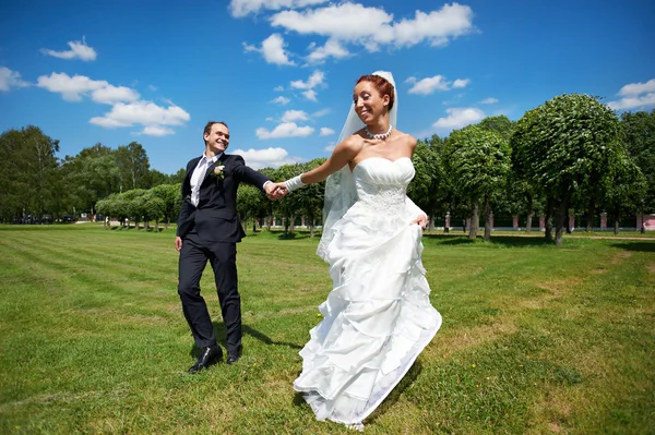 Glücklicher Bräutigam und glückliche Braut beim Hochzeitsspaziergang — Stockfoto