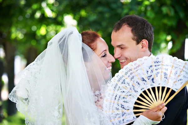 Happy bride and groom with fan — Stock Photo, Image