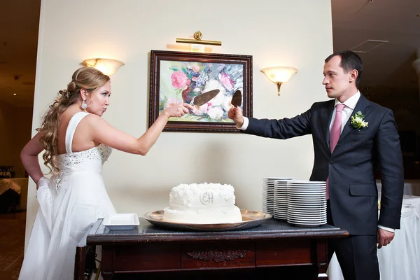 Funny bride and groom near wedding cake — Stock Photo, Image