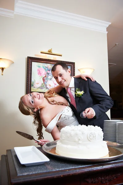 Bride and groom near wedding cake — Stock Photo, Image