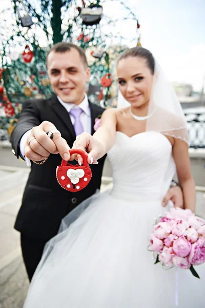 Happy bride and groom with a padlock — Stock Photo, Image