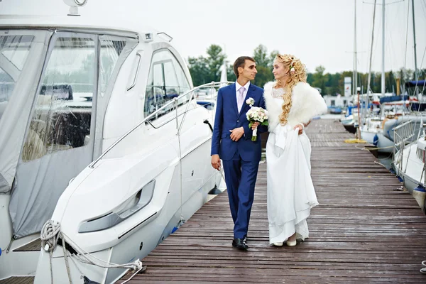 Romantici sposi vanno al molo con barche a vela — Foto Stock