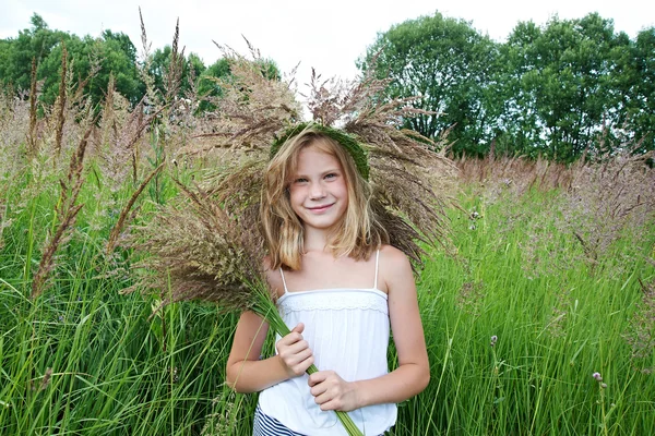 Fille dans une couronne d'herbe avec des épillets — Photo