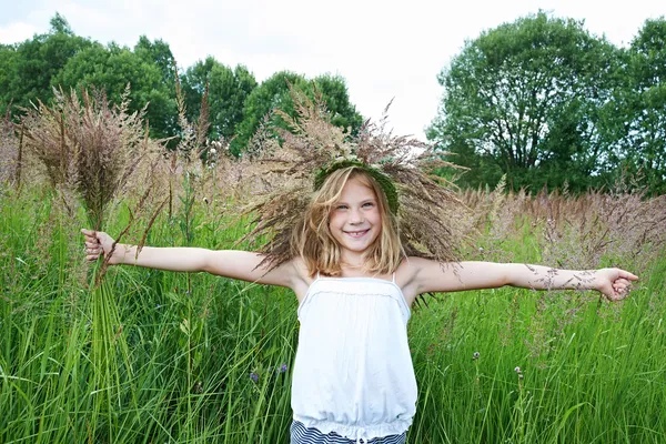 Mädchen in einem Kranz aus Gras mit Stacheln — Stockfoto