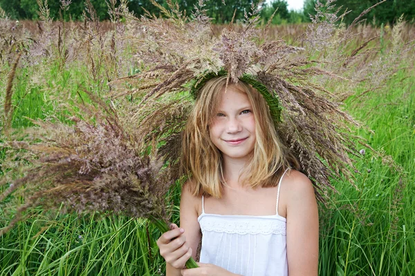 Meisje in een krans van gras met spikelets — Stockfoto