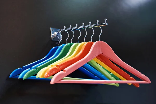 Colorful coat hangers on clothes rail in the store