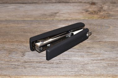 stapler isolated on wooden background - close-up