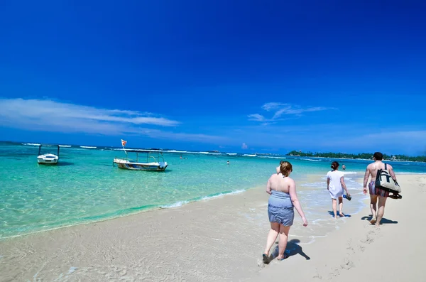 Menschen gehen am Strand spazieren — Stockfoto