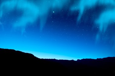 Stars and northern lights over mountain clipart