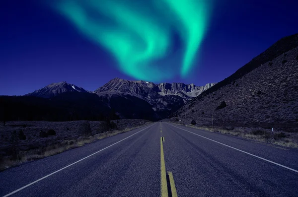 Northern lights over mountain highway — Stock Photo, Image