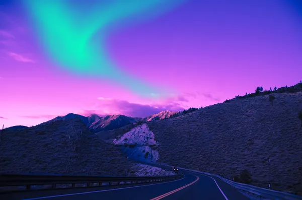 Luces boreales sobre carretera montaña — Foto de Stock