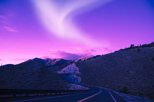 Luzes do norte sobre a estrada da montanha — Fotografia de Stock