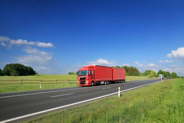 Otobanda hareket eden bir kamyonla manzara.