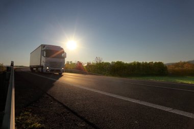 Gün batımında hareket eden bir kamyonla manzara 