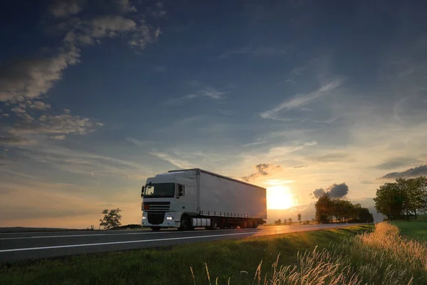 Landscape with a moving truck at sunset