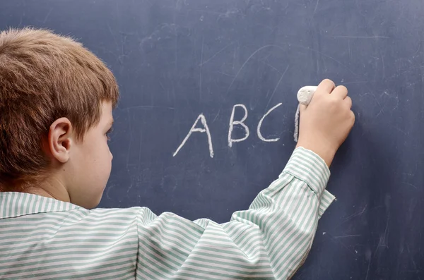 Junge schreibt Alphabet — Stockfoto