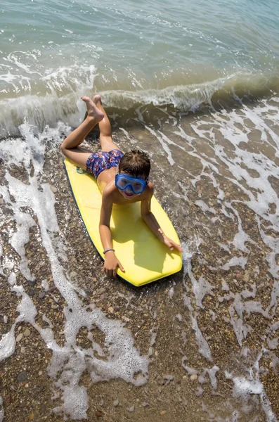 Criança surfando na praia — Fotografia de Stock