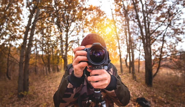 秋の森で写真を撮る若い男性写真家の正面図 — ストック写真